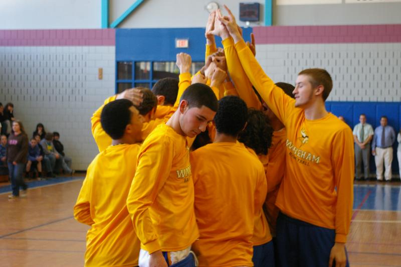 Wareham varsity boys basketball team put their hands together during the a March 12 pep rally at Wareham High School supporting their semi-final game against Danvers on the same day. The rally also honored the qualifiers and winners of the State Career Development Conference, a competition for developing business leaders held from March 8-10 in Boston in which 4 Wareham High School marketing students won awards. BY RISHI SIDHU
