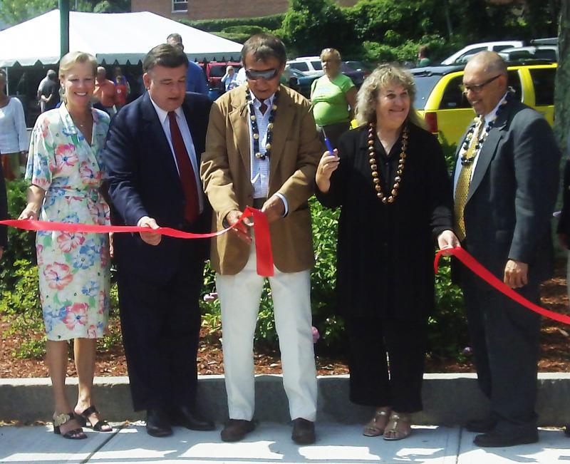 The ribbon is cut as Pezzoli Square is rededicated on Friday in honor of former Wareham Police Officer Raymond Pezzoli. From left to right, State Representative Susan Williams Gifford, State Senator Marc Pacheco, Ray and Jeannie Pezzoli, the son and daughter of Officer Pezzoli, and Community and Economic Development Authority Director Salvador Pina. BY RISHI SIDHU