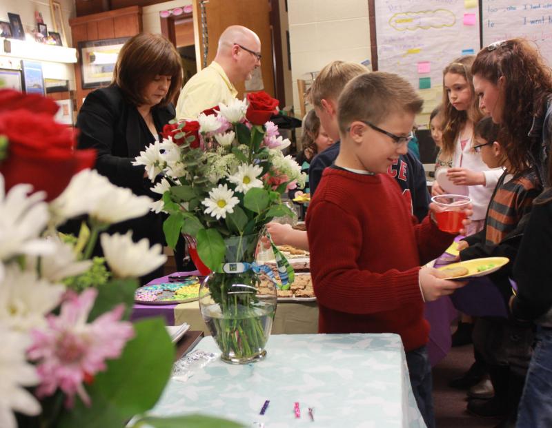 Teachers Patricia Nelson (left) and Patrick Roche (center) serve desserts to students, who brought and shared them with their mothers and motherly figures. Roche and Nelson have hosted the Mother's Day Celebration for 13 years at John W. Decas Elementary School in Wareham. BY ZARRIN TASNIM AHMED