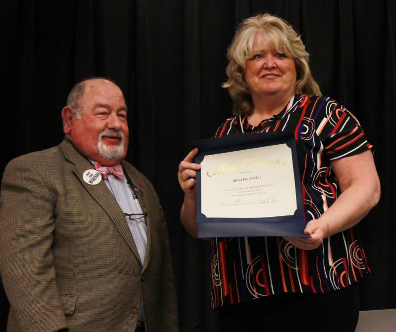 Kristine Ansell (right) is recognized for 20 years of service to John W. Decas Elementary School by School Committee Chair Melvin Lazarus (left). "Every day she exhibits the care necessary when working with young children," said Principal Donna Noonan. BY ZARRIN TASNIM AHMED
