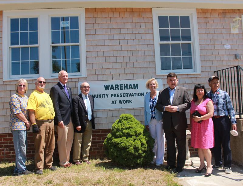 From left: Community Preservation Committee member Sandy Slavin, Selectman Alan Slavin, Congressman Bill Keating (D-Mass.), Lawrence DiCara, State Rep. Susan Williams Gifford (R-Wareham), State Senator Marc Pacheco (D-Taunton), Wareham Historical Society's Angela Dunham, and Post #220 Commander Robert Powilatis stand in front of the newly renovated American Legion Post #220, where a sign says "Wareham Community Preservation Funds at Work." BY ZARRIN TASNIM AHMED