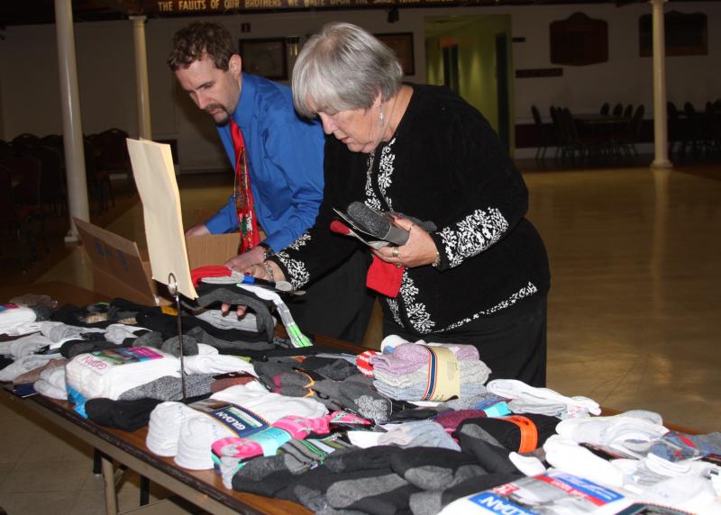 Sue Gifford of the Wareham/New Bedford Lodge of Elks and Michael O'Neill Jr., Resource Center Specialist for Turning Point, load donated socks for area homeless on Thursday. BY MATTHEW BERNAT