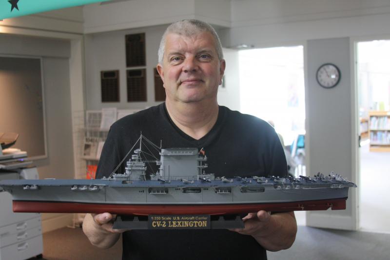 Captain John Charlebois shows off a model of the USS Lexington, which is one of his favorites. BY MATTHEW BERNAT