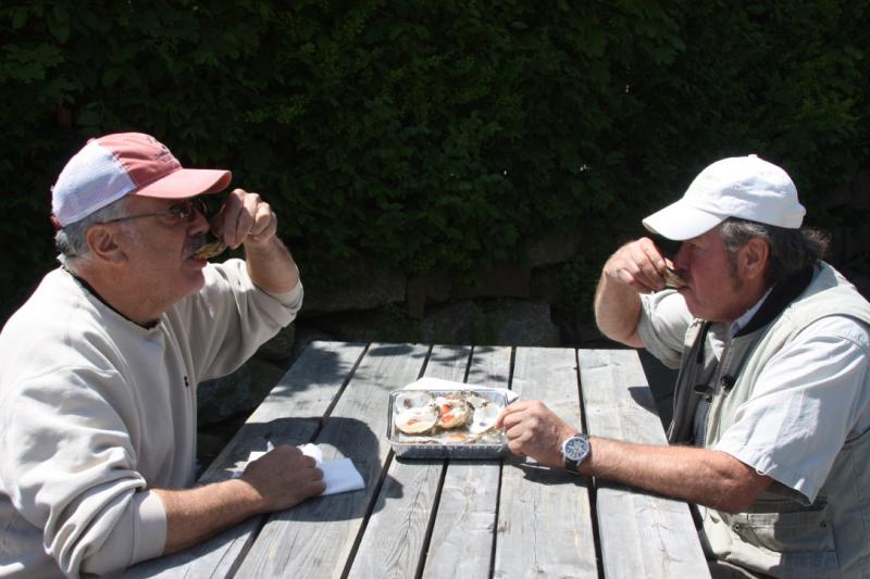 Shellfishermen Phil Wentworth (left) and Peter Reed enjoy the first of many oysters. BY LYDIA GOERNER