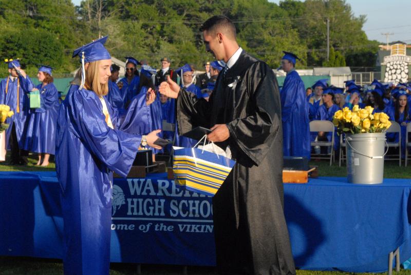 Valedictorian Brett McSherry performs a secret handshake before accepting her diploma. BY LYDIA GOERNER