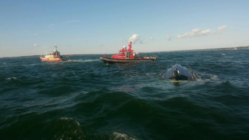 Coast Guard crews and first responders at the scene of a capsized boat where 12 people were pulled from the water. COURTESY U.S. COAST GUARD