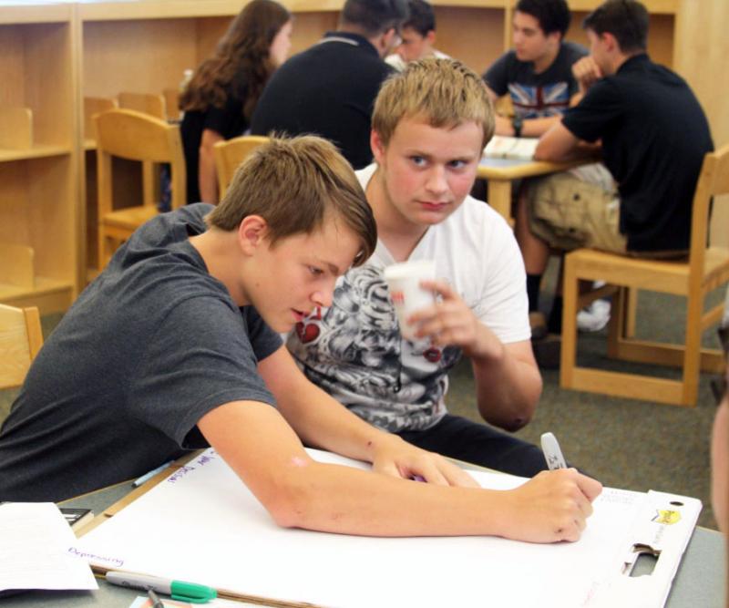 Noah Marriott, 14, of Wareham, writes answers to discussion questions with his group. BY LYDIA GOERNER