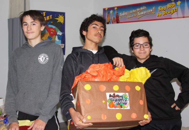 From left, eighth graders Ryker King, Brenden Veiga and Jakob Enright help with the donations. BY LYDIA GOERNER