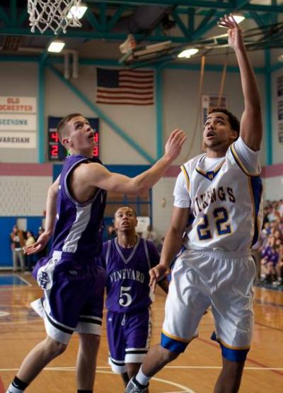 Ryan Pina finishes a drive for two points over Martha's Vineyard player Steve Handy. BY ANDREW W. GRIFFITH