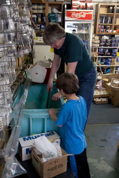 Thomas helps Matthew Pearl, 8, pick out some minnows for bait. Pearl and his brother Joseph, 7, are good for ten award-winning fish a year, Thomas said. But he hinted that the best angler in the family may be their 11-year-old sister Angela. BY ANDREW W. GRIFFITH