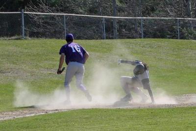 Wareham senior Jordan Rezendes bounces up from a slide as a bad throw passes the third basemen and Rezendes starts for home to score a run. BY DICK SEARLES