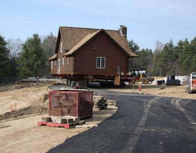 Once the house was oriented in the correct direction, the crew jacked up the home on the frame so that they could rotate the wheels to point straight down towards the new foundation (if the picture were wider, the foundation would be in the left foreground). BY JAIME REBHAN