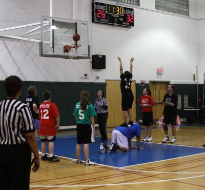 Middle school custodian Jimmy Couto gives Minot Forest Elementary technology paraprofessional Renee Fernandes a boost, helping her sink this free throw. BY JAIME REBHAN