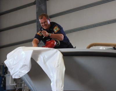 Assistant Harbormaster Garry Buckminster takes some of the shrink wrap off the new boat. BY JAIME REBHAN