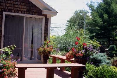 In addition to specimen plants, arbors, and perennial beds, creative container plantings decorated the porch. BY CYRUS MOULTON