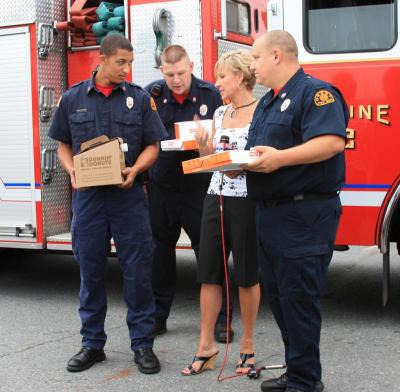 Kim Carrigan speaks with Onset firefighters during the "Firehouse Friday" segment of the show. The station was given donuts and coffee from Dunkin Donuts as a thank you for the work that the employees and volunteers do. BY JAIME REBHAN