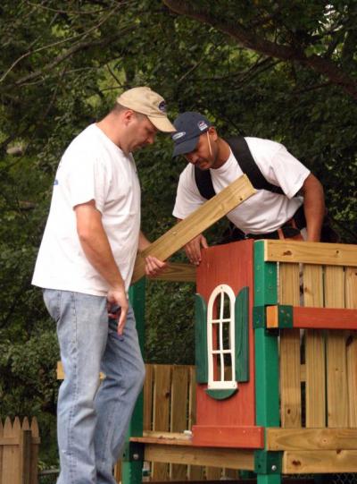 Pete McCarthy, left, and Will Martinez put together a new play set at the school. The set was formerly a floor-model at Lowe's. They added a little extra reinforcement to the set now that it's in a playground rather than in the store. BY CYRUS MOULTON