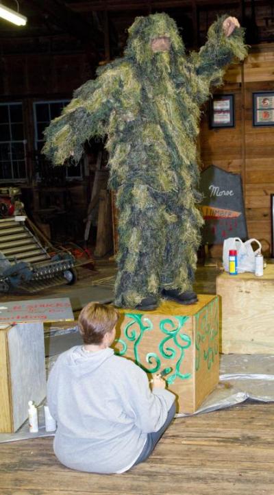 Terrifying Topiary Derek Drinkwater practices his poses while his wife, Jennifer, decorates his stand. BY ANDREW W. GRIFFITH