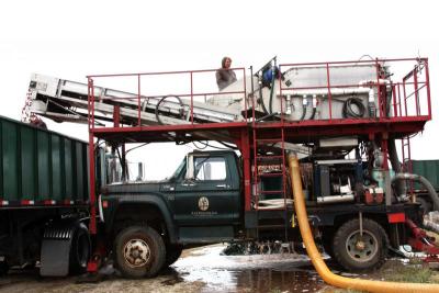 In the separator, here on the top of the truck, jets of water wash the berries and push the dirt, rotten berries, and other byproduct - including the occasional frog! - through slats into a waiting truck. Water is filtered and returned to the bog in the yellow pipe, while a conveyor belt moves the ripe berries to a truck headed to the Ocean Spray plant. BY JAIME REBHAN