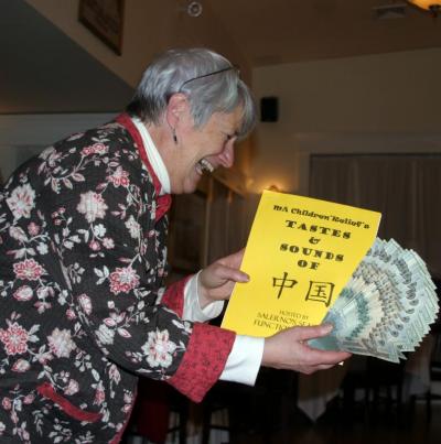 Sally Morrison displays a fan of bills, part of a $4,000 donation from MA Children's Relief to Turning Point as a result of The Tastes and Sounds of China fundraiser. Each year, the MA Children's Relief hosts a dinner which "visits" a new country to sample regional cuisine and music. In five years of holding the event at Salerno's, the group has raised $20,000 for Turning Point. Next year, they are "traveling" to France. BY CYRUS MOULTON