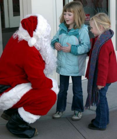 Carlie Hutchings, left, and Anna Cortell, tell Santa that they've been good girls this year. BY CYRUS MOULTON
