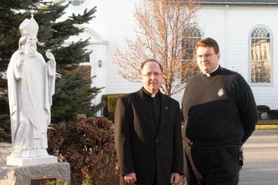 Church leaders. Father John M. Sullivan, pastor, left, and Father Ron Flynn, parochial vicar, stand alongside the church's patron saint, St. Patrick. BY CYRUS MOULTON