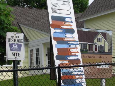 Progress in the $650,000 Spinney fund-raising campaign was marked on a stack-of-books sign outside the Onset structure. BY PATRICK LESTER