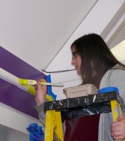 Elizabeth Lindquist, age 16, a TAB member from the group's inception helps paint the upper trim of the new teen section of the library. COURTESY LAURIE CAVANAUGH