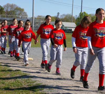 Members of the "Threshers," a junior league division team, walk out on the field during opening ceremonies. BY RISHI SIDHU