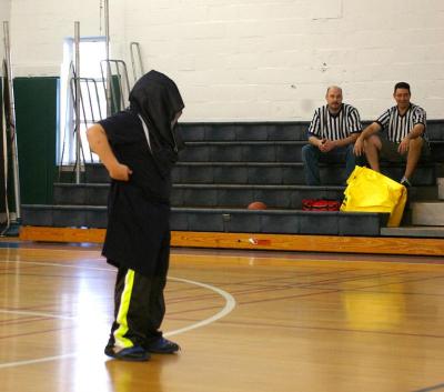 A Minot Forest 5th grader had the challenge of putting on over-sized clothes and getting the ball into the basket during a contest held after the first quarter of the game. BY RISHI SIDHU