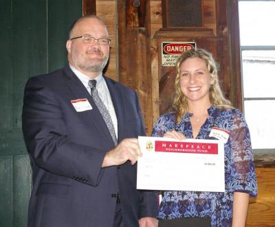 Kim Frink (left), volunteer with Junior Achievement of Southern Massachusetts, and Caroline Paradis, president of Junior Achievement, receive their $4,000 award on Thursday. BY RISHI SIDHU