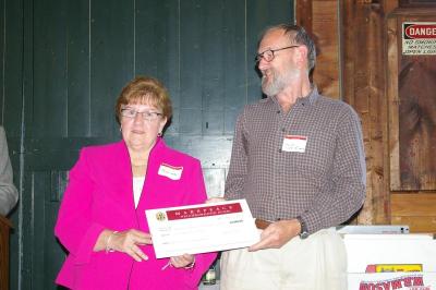 Claire Smith, brother of former A.D. Makepeace employee Robert "Grumpy" Conway, gives an award to a representative of the Manomet Center for Conservation Sciences in Plymouth. A.D. Makepeace asks Smith to give the award in her brother's name and chooses the award recipient based on whether it is the type of organization that Conway, an aficianado of nature, would have supported. BY RISHI SIDHU