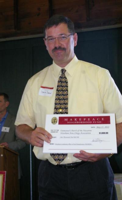 A representative from the Emmanuel Church of the Nazarene and the Wareham Area Clergy Association receives a $1,000 award to help kick start the "Wareham Community Plan to End Homelessness." BY RISHI SIDHU