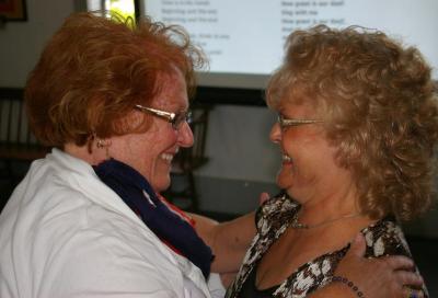 Barbara Holmes (left) shares a smile and a hug with newly licensed minister Jan Porter. BY RISHI SIDHU