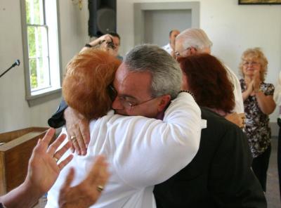 Pastor Bob Cordeiro hugs friend Barbara Holmes who traveled from Rhode Island to show her support for the ceremony. BY RISHI SIDHU