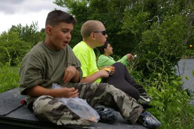 Owen Reis (left) eats fruit loops as he sits with friend Brenden Griffin during the derby. Reis' mother Nichole McWilliams fishes in the background. BY RISHI SIDHU