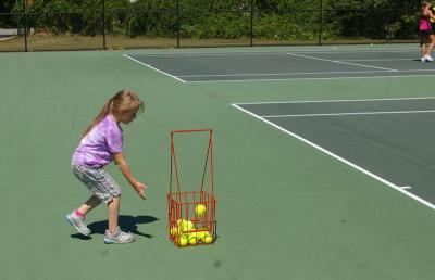 Ball girl Angeleena Knight, a 6 year old resident of Wareham, drops a ball into the basket. BY RISHI SIDHU