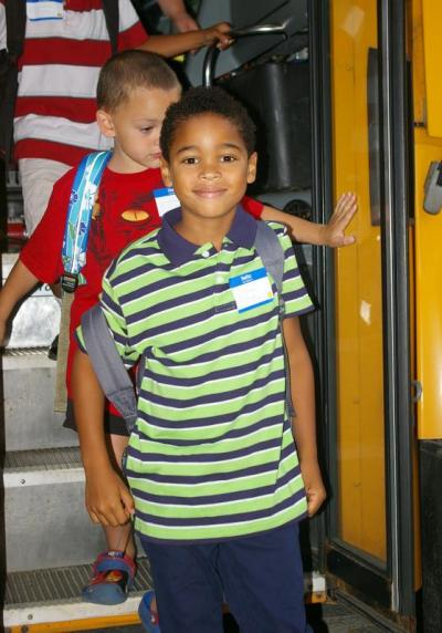 First grader Policarpo DaCruz Jr. gets off the bus at Minot Forest Elementary School. BY RISHI SIDHU
