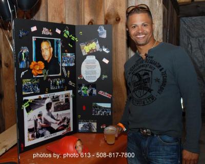 Jose Ledesman stands with a poster commemorating the life of Boston firefighter Rick Graham. COURTESY RICK GRAHAM COMMITTEE