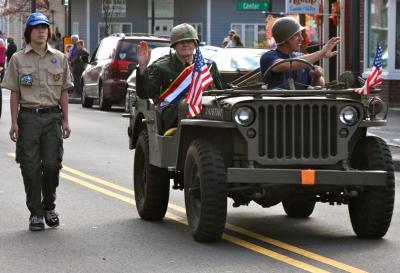 Boy Scout Jesse Sarkisian walks with the WWII Jeep escorting Grand Marshal Vernon Ingraham. BY JAIME REBHAN