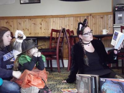 Kat Jones, one of the event organizers, reads spooky stories at the Pier View Restaurant. BY CAITLIN RUSSELL