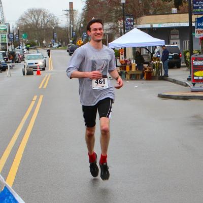 Wareham Week's own Bill Whelan smiles as he crosses the finish line of Sunday's race. BY NICK WALECKA