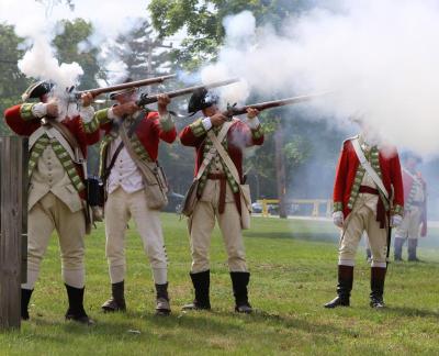 British soldiers fire on the American contingent at a reenactment of a typical 18th century battle in America. BY NICK WALECKA