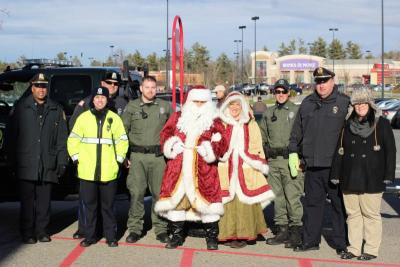 From left: Sgt. Walter Correia, Officer Ashley Duff, Officer Dean Decas, Asst. Harbormaster Jamie McIntosh, Mr. and Mrs. Santa Claus, Asst. Harbormaster Mike McGuire, Lt. John Walcek, and Target representative Angela King, all of whom helped the Melloni Toy Drive with the Stuff-a-Cruiser campaign earlier in December. BY NICK WALECKA