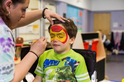 Daniel Delk, 5, gets his face painted in the style of the Marvel Comics character Iron Man. BY CAROLYN BICK