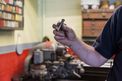 Firefighter Peter Dipasqua holds up a bolt he has finished creating. "I have a mechanical background," Dipasqua said of his abilities to do odd jobs around the station. "If I can do it, I do it." BY CAROLYN BICK