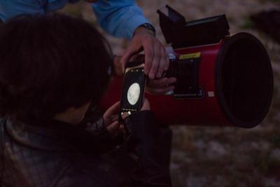 Senior Samantha King uses her cell phone to take a picture of the moon through a telescope lens. BY CAROLYN BICK