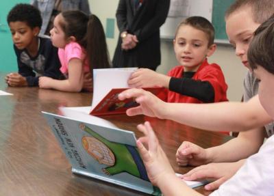 Students flip through one of three children's books written by Cardinal, "Sully P. Snooferpoof's Amazing New Shadow." His newest book, a sequel to this one titled "Sully P. Snooferpoof's Amazing New Forcefield," will come out next month. Cardinal brought an unpublished copy of the "never seen before" novel. BY ZARRIN TASNIM AHMED