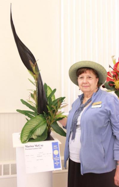Marisa McCoy stands next to her design for "Dance of the Hours," which won first place in its category at the Wareham Garden Club's "Fantasia" Flower Show. BY ZARRIN TASNIM AHMED