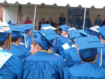 Graduates sit in the rain during the Upper Cape Cod Technical Regional High School graduation ceremony. BY ZARRIN TASNIM AHMED
